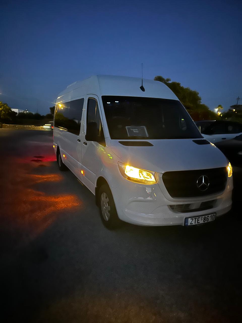 White Mercedes-Benz Sprinter shuttle van parked outdoors at dusk, available for wedding and event transportation in Sifnos.